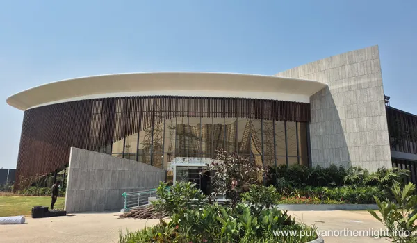 Side view of the contemporary Purva Northern Lights sales gallery featuring a curved roofline, large glass windows, and stone-textured wall panels.